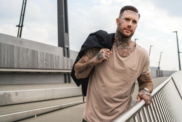 Portrait eines jungen muskulösen Mannes mit Tattoos, Sweater Shirt. Lifestyle Mode Influencer