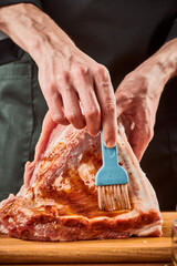 Man brushing beef ribs with marinade, close-up shot