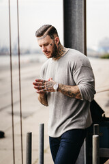 Portrait eines jungen muskulösen Mannes mit Tattoos, Sweater Shirt. Lifestyle Mode Influencer - 389831540