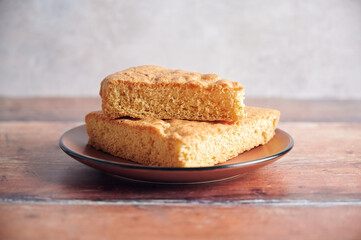Delicious freshly baked sponge cake on a plate. Rustic background