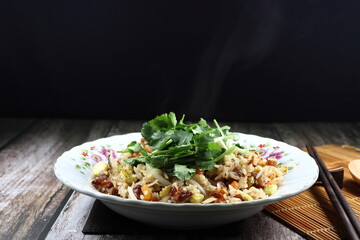 Fried and stirred rice with chopped fresh carrot, onion and baby corn topping with fresh coriander on the plate. Famous traditional breakfast menu in Asia restaurant. High fiber and low fat food. 