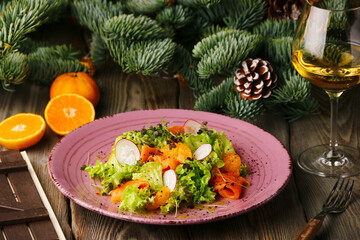 salmon salad with orange, guacamole and glass of white wine on christmas background
