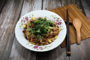 Fried and stirred rice with chopped fresh carrot, onion and baby corn topping with fresh coriander on the plate. Famous traditional breakfast menu in Asia restaurant. High fiber and low fat food. 