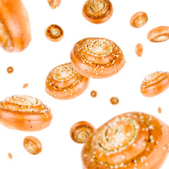 Many cinnamon roll buns free falling on white background. Selective focus - shallow depth of field.