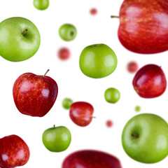 Many green and red apples free falling on white background. Selective focus - shallow depth of field.