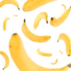 Many bananas free falling on white background. Selective focus - shallow depth of field.