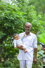 Grandfather carrying his granddaughter on his hand.