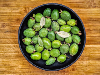 A feijoa fruits (known yet as acca sellowiana) on a rustic table.
