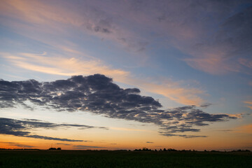 blue sky with variegated clouds over the field