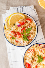 Flatlay Tabouleh is an Arabic vegetarian salad made with couscous, tomatoes, parsley. Healthy lunch
