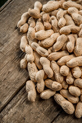 Fototapeta na wymiar Dried peanuts closeup photo. Peanut in the shell. Food background of peanuts, healthy vegan food