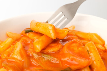 Tteokbokki with soup on white background