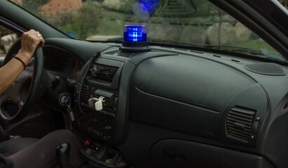 Fototapeta na wymiar close-up of a blue police flashing light on inside the car