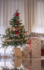 Decorated Christmas tree with a big window in a Spanish house in Valencia. Christmas Photography 2020. 