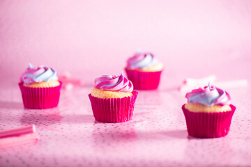 Rainbow icing and vanilla cupcake, sweet food background.