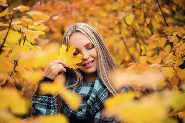 Beautiful Autumn Woman with Autumn Leaves on Fall Nature Background