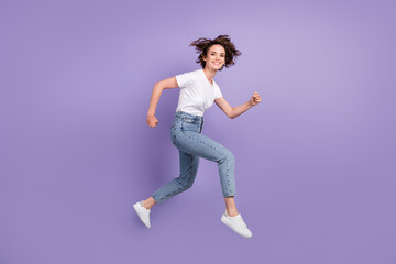 Fototapeta na wymiar Full length body size side profile photo of girl jumping high hurrying up on sale smiling isolated on bright violet color background