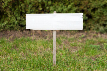 Blank mock up wooden sign in the garden. Concept for advertisement, guide board, tourism wood sign.