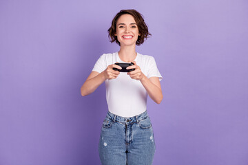 Photo portrait of girl laughing holding controller playing video game on psp isolated on bright violet color background © deagreez
