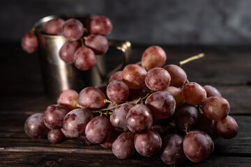Autumn still life of red grapes on wooden background
