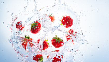 Fototapeta na wymiar Strawberries splashing into clear water, view from top