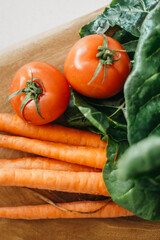 Close up shot of tomatoes, carrots and collard greens