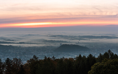 Graz city covered if fog on autumn morning during sunraise.