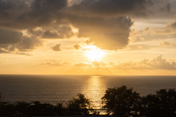 Landscape of the golden light sunset in the evening in Phuket Thailand Asia over the white summer clouds over the seascape with the still waves in the ocean