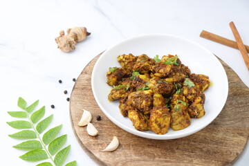 Goat Brain masala or Bheja Fry, it's a popular Indian dish. served on a white plate. Indian spices. Cooking ingredients background. selective focus. Copy space.