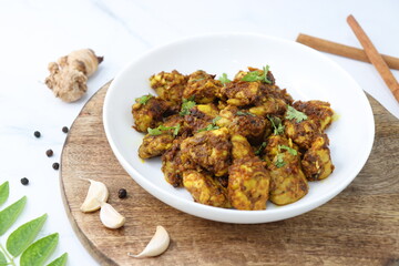 Goat Brain masala or Bheja Fry, it's a popular Indian dish. served on a white plate. Indian spices. Cooking ingredients background. selective focus. Copy space.