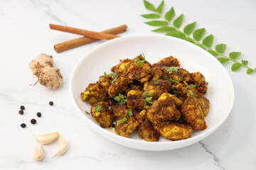 Goat Brain masala or Bheja Fry, it's a popular Indian dish. served on a white plate. Indian spices. Cooking ingredients background. selective focus. Copy space.