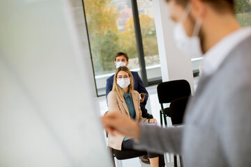 Business people with protective facial masks on education forum business seminar at corporate company