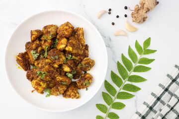 Goat Brain masala or Bheja Fry, it's a popular Indian dish. served on a white plate. Indian spices. Cooking ingredients background. selective focus. Copy space.