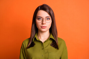 Photo portrait of serious calm female worker wearing spectacles isolated on vibrant orange color background