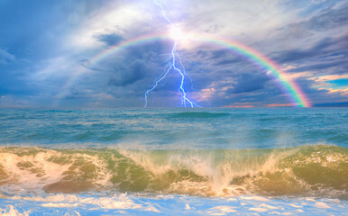 Amazing sunset over the stormy sea thunder and lightning in the background with rainbow