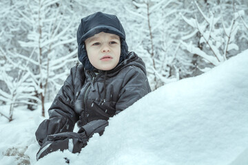 Fototapeta na wymiar portrait of a boy on a snowy background.