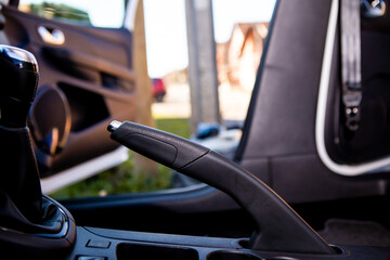 Focus on the handbrake in the car that is just being washed. All seats have been removed from the car.