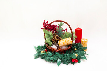 Christmas basket with branches of spruce berries a garland of candles on a white background with space for writing or text