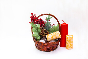 Fototapeta na wymiar Christmas basket with branches of spruce berries a garland of candles on a white background with space for writing or text