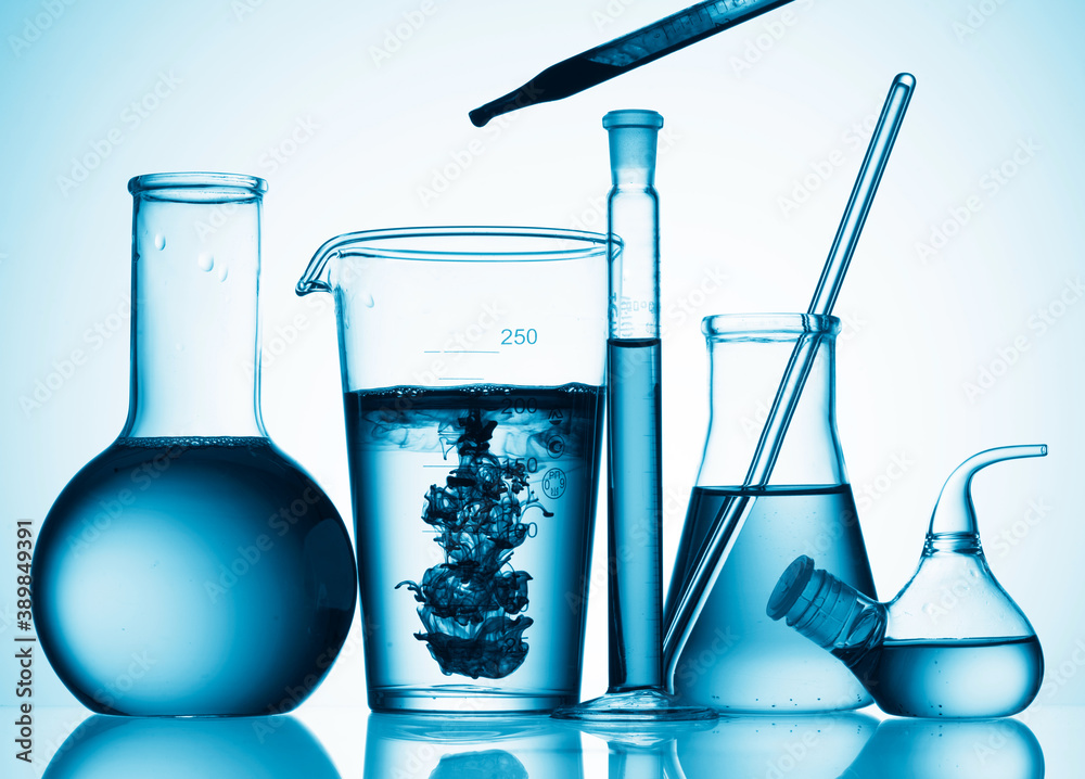 Wall mural different laboratory glassware with color liquid and with reflection