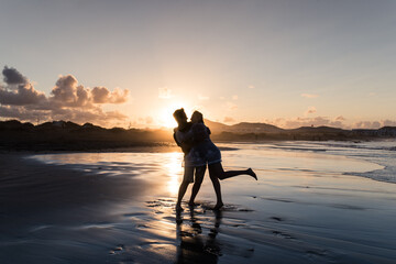 Silhouette of a couple hugging and enjoying a sunset on a beach in Lanzarote. Honeymoon