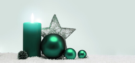 Christmas decoration and green advent candle isolated on blur gray background.