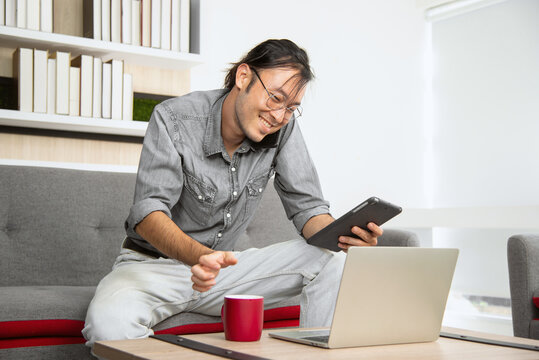 Asian Guy Working On Couch As Easy