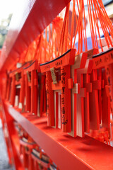 Small wooden plaques or Ema in form of red Torii gate contains prayers or wishes in Kyoto, Japan.