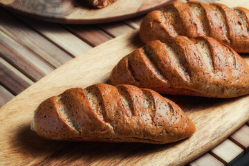 freshly baked loaf with poppy seeds on a wooden stand
