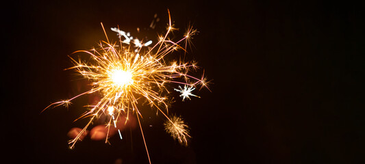 Silvester / New year background - Woman holds sparkling sparkler in her hand at dark night