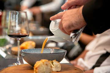 Butler pouring soup for the guest