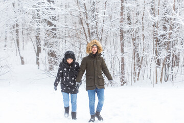 Fototapeta na wymiar Happy loving couple having fun outdoors in snow park. Winter vacation