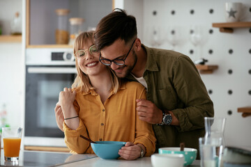 Young couple eating breakfast at home. Loving couple enjoying in the kitchen...