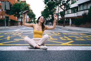 Fototapeta na wymiar Young woman having fun in lotus pose on street